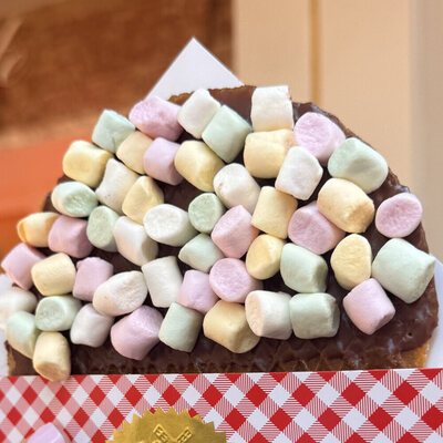 A chocolate-dipped giant stroopwafel covered in pastel mini marshmallows
