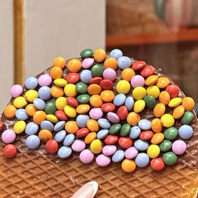 A chocolate-dipped giant stroopwafel covered in coloured chocolate beans