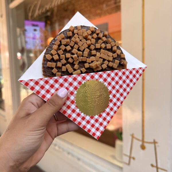 A giant stroopwafel covered in milk chocolate and caramel fudge cubes, in a checked wrapper with the gold Dutch Bar seal